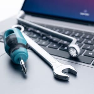 Computer fixing, service or maintenance concept background. Working tools on modern laptop computer